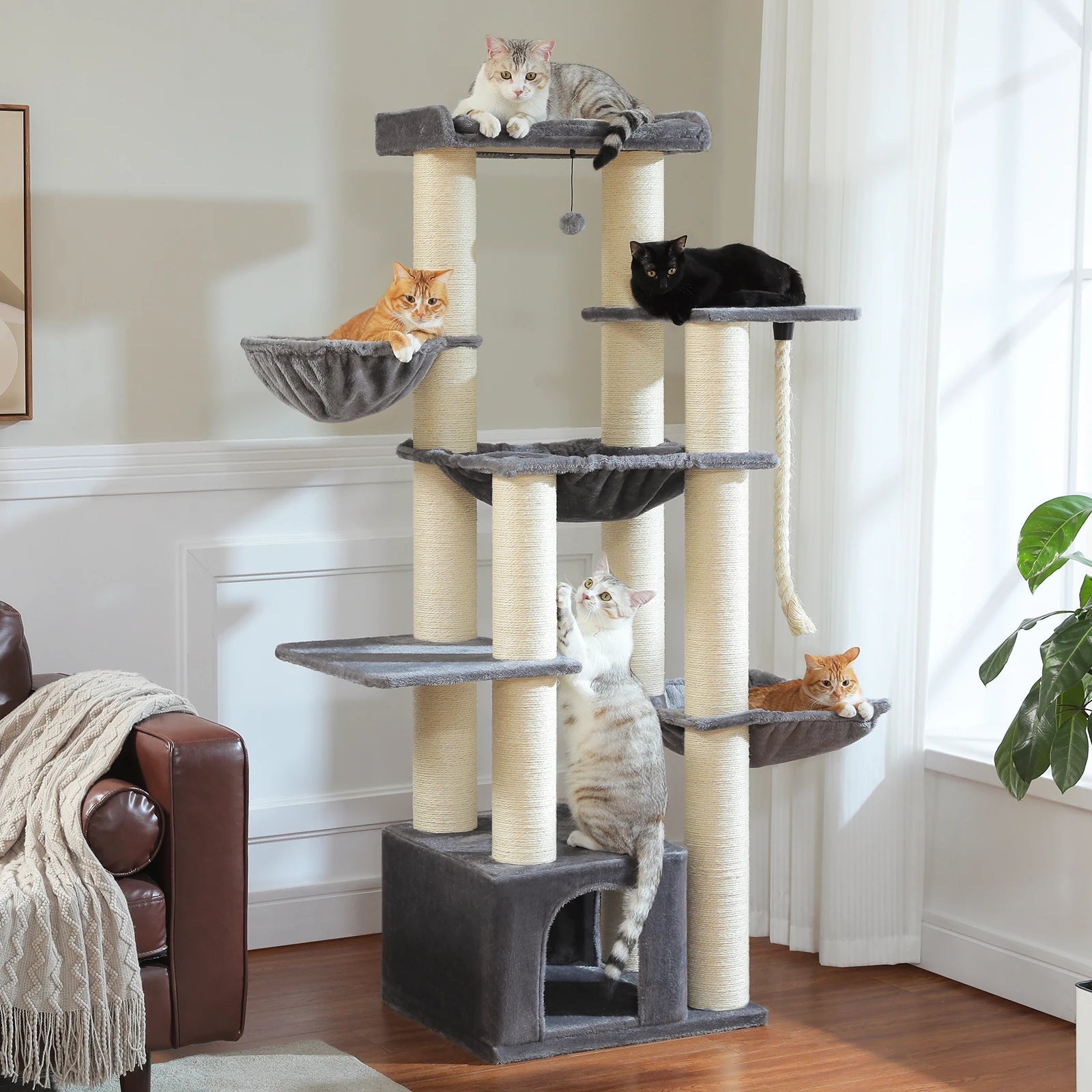 Cat tree with multiple cats on different levels in a living room.